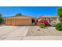 Charming home featuring a desert landscaped front yard and a spacious three-car garage at 16972 W Anasazi Ct, Surprise, AZ 85387