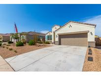 Charming single-story home with a two-car garage, low maintenance landscaping, and a well-lit exterior at 30128 W Weldon Ave, Buckeye, AZ 85396