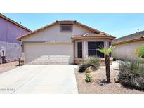 Charming single-story home with a well-manicured lawn and a two-car garage at 42382 W Hillman Dr, Maricopa, AZ 85138
