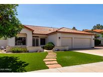 Charming single-story home featuring desert landscaping, a tile roof, and a two-car garage at 5517 W Aster Dr, Glendale, AZ 85304