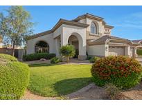 Stunning home exterior featuring lush landscaping, a well-maintained lawn, and an arched entrance at 6435 E Monte Cristo Ave, Scottsdale, AZ 85254