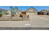 Charming single-story home featuring desert landscaping, a two car garage and a gated front yard at 6804 W Turquoise Ave, Peoria, AZ 85345