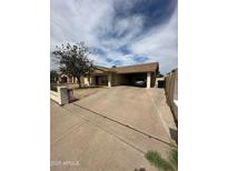 Single-story home with covered parking, neutral exterior, and low-maintenance landscaping at 1045 S Solomon St, Mesa, AZ 85204