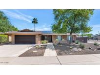 Charming single-story brick home featuring a well-manicured front yard and a welcoming entrance at 10590 E Mercer Ln, Scottsdale, AZ 85259