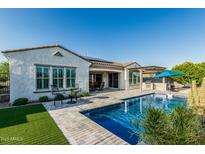 Inviting backyard with a sparkling pool, outdoor kitchen, and covered patio seating area at 20595 W Pasadena Ave, Buckeye, AZ 85396