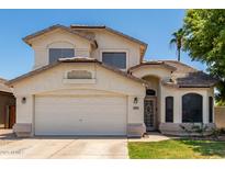 Charming two-story home featuring a well-maintained front yard and attached two-car garage on a sunny day at 2963 S 83Rd St, Mesa, AZ 85212