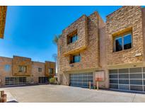 Exterior view of modern townhomes with stone accents and attached garages under a clear, blue sky at 312 S Hardy Dr # 106, Tempe, AZ 85281