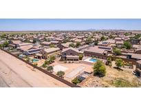 Expansive aerial view of a neighborhood with pools, sport courts and desert landscaping at 36645 W Bilbao St, Maricopa, AZ 85138