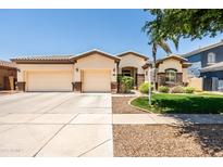 Charming single-story home featuring a spacious three car garage, manicured lawn, and stone accents at 4614 E Reins Rd, Gilbert, AZ 85297