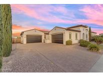 Elegant home exterior with spacious three-car garage, paver driveway, and manicured landscaping under a pastel sky at 5941 S Cambridge St, Chandler, AZ 85249