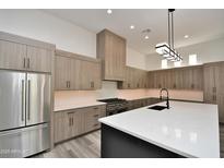 Modern kitchen featuring quartz countertops, stainless steel appliances, and custom wood cabinetry at 8934 E Rusty Spur Pl, Scottsdale, AZ 85255