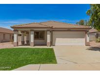 Charming single-story home featuring a desert landscape, a two-car garage, and a cozy front porch at 10212 E Caballero St, Mesa, AZ 85207