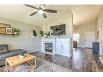 Inviting living room features a fireplace, dark wood floors, ceiling fan, and neutral wall color at 1212 S Boulder St # C, Gilbert, AZ 85296