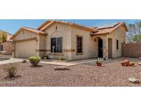 Charming single-story home featuring a red tile roof, stucco exterior, and low-maintenance desert landscaping at 16160 W Custer Ln, Surprise, AZ 85379