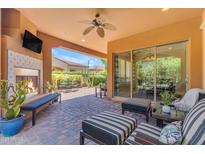 Outdoor patio with fireplace, ceiling fan, and comfortable seating, perfect for entertaining at 1771 E Alegria Rd, Queen Creek, AZ 85140