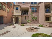 Charming multi-level townhome with a well-maintained walkway and front patio at 1836 N 77Th Gln, Phoenix, AZ 85035