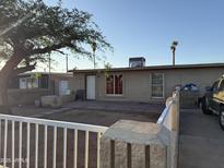 Cozy home exterior features a quaint yard and neutral-toned facade, with mature trees providing shade at 3946 W Holly St, Phoenix, AZ 85009