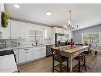 Modern kitchen with white cabinets, stainless steel appliances, and a butcher block island with seating at 427 S 80Th Way, Mesa, AZ 85208