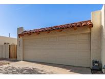 Attached two-car garage featuring a tile roof overhang and convenient driveway access at 4722 W Via Cynthia --, Glendale, AZ 85301