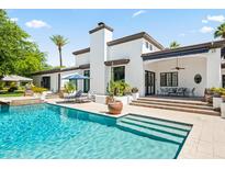 Stunning backyard with a refreshing pool and stylish outdoor lounge area with white stucco home at 5051 E Lafayette Blvd, Phoenix, AZ 85018