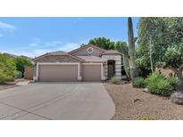 Charming single-story home boasts a stone facade, desert landscaping, and three-car garage at 5733 E Jaeger St, Mesa, AZ 85205