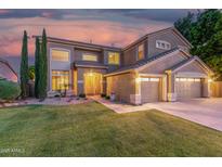 Inviting two-story home featuring a manicured lawn, desert landscaping, and a convenient three-car garage at 6961 W Honeysuckle Dr, Peoria, AZ 85383
