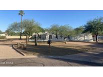 Charming single-story home featuring desert landscaping, mature trees, and a low privacy wall at 7044 E Ann Way, Scottsdale, AZ 85254
