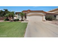 Charming home with desert landscaping, palm trees, and a two-car garage at 19007 N 79Th Dr, Glendale, AZ 85308