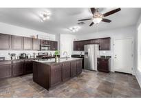 Spacious kitchen features dark wood cabinets, stainless steel appliances and a large granite island at 21014 W Ridge Rd, Buckeye, AZ 85396