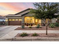 Charming single-story home with a two-car garage, inviting front porch, and desert landscaping at 21022 E Arroyo Verde Ct, Queen Creek, AZ 85142