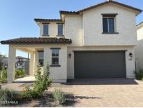 Two story home featuring neutral stucco, a two-car garage, covered entry, and red-tile roof in a suburban neighborhood at 3363 S 180Th Ln, Goodyear, AZ 85338