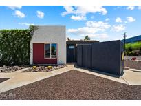 An exterior shot showing the home's unique architectural design with a desert landscape and vibrant greenery at 3551 N 12Th St # 101, Phoenix, AZ 85014