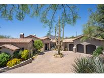 Beautiful desert home featuring a circular brick driveway, mature cacti, and multiple garage spaces at 41916 N 101St N Pl, Scottsdale, AZ 85262