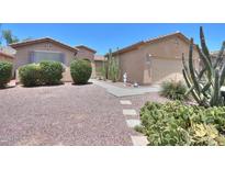 Well-maintained desert landscape in the front yard with a walkway leading to the front door and garage at 42360 W Abbey Rd, Maricopa, AZ 85138