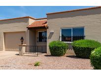 Cozy single-story home features a charming front yard with desert landscaping and an attached garage at 4502 E Carol Ave # 4, Mesa, AZ 85206