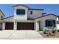 Inviting two-story home featuring a three-car garage, desert landscaping, and a charming architectural design at 4930 W Brown St, Glendale, AZ 85302