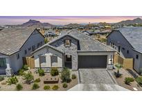 Charming single-Gathering home featuring stone accents, a two-car garage, and professionally landscaped front yard at 5724 E Scarlet St, Mesa, AZ 85215