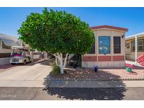 Cozy home featuring charming landscaping and a convenient golf cart parked in the driveway at 8700 E University Dr # 1205, Mesa, AZ 85207