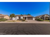 Charming single-story home featuring a tile roof, desert landscaping, and a two-car garage at 10529 E Posada Ave, Mesa, AZ 85212