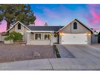 Charming single-story home with a two-car garage, complemented by professional landscaping and a brick entryway at 16437 N 61St Ave, Glendale, AZ 85306