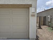 Close-up of the garage with house number, exterior lighting, and gated side yard at 18361 E Eloisa Dr, Gold Canyon, AZ 85118