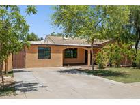 Charming single-story home with a covered porch, mature trees, and a driveway at 2636 N Dayton St, Phoenix, AZ 85006