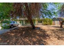 Cozy single story home with mature landscaping, and a silver car parked in the driveway at 3226 W Grovers Ave, Phoenix, AZ 85053