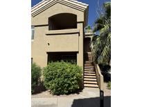 Exterior view of a two story tan home with a staircase, beautiful shrubbery, and a small balcony at 5335 E Shea Blvd Blvd # 2095, Scottsdale, AZ 85254