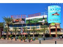 View of the Westgate Entertainment District with outdoor dining, palm trees, and water features on a sunny day at 6745 N 93Rd Ave # 1129, Glendale, AZ 85305