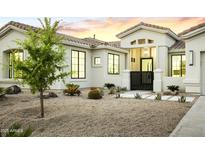 Charming home's exterior features a well-maintained desert landscape and inviting entrance with black metal gate at 7774 E San Fernando Dr, Scottsdale, AZ 85255