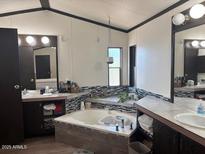 This primary bathroom has dual sinks, accent tile and a relaxing soaking tub at 9302 E Broadway Rd # 129, Mesa, AZ 85208