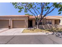 Charming single-story home featuring a two-car garage and mature shade tree in the front yard at 1021 S Greenfield Rd # 1211, Mesa, AZ 85206