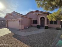 Charming single-story home featuring a two-car garage, low maintenance landscaping, and a covered front entry at 11338 E Contessa St, Mesa, AZ 85207