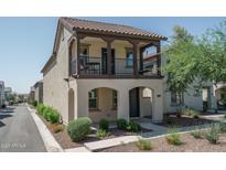 Charming two-story home featuring a balcony, landscaped front yard, and a covered entryway, offering curb appeal at 1799 N 209Th Ave, Buckeye, AZ 85396